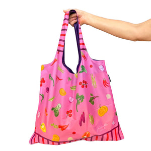 Arm holding pink reusable shopping bag