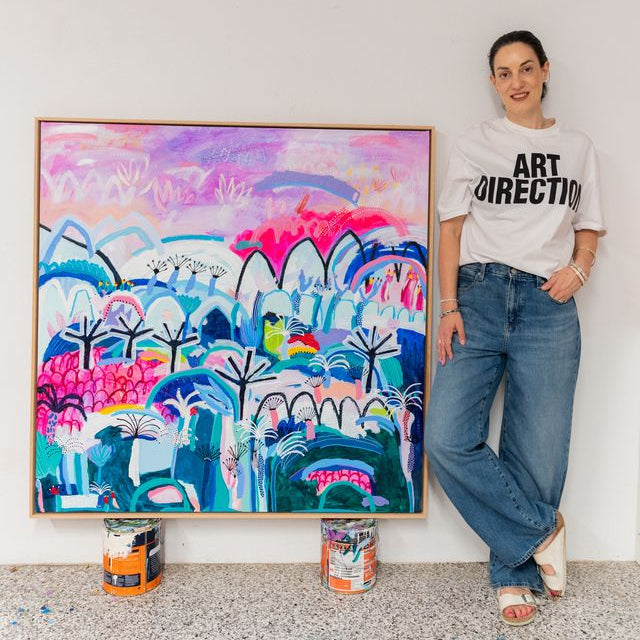 Person standing next to a colorful abstract painting in an indoor setting