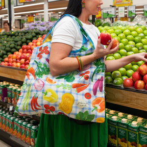 Shopping Bag over arm in front of apples and fresh produce