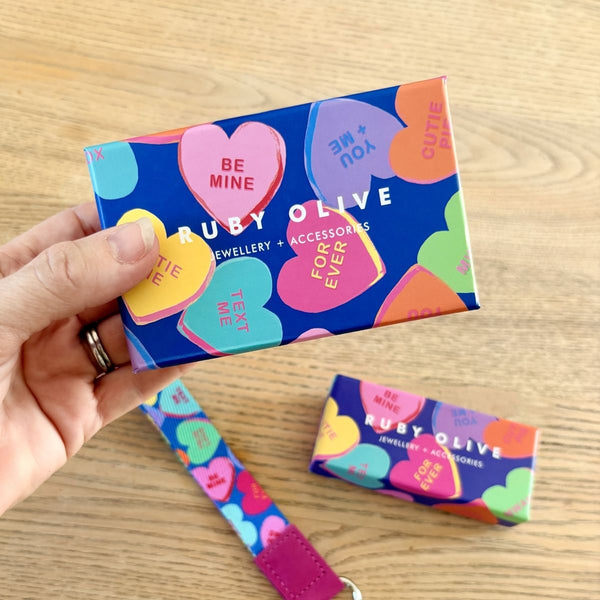 Colorful jewelry box with 'Ruby Olive' branding on a wooden surface