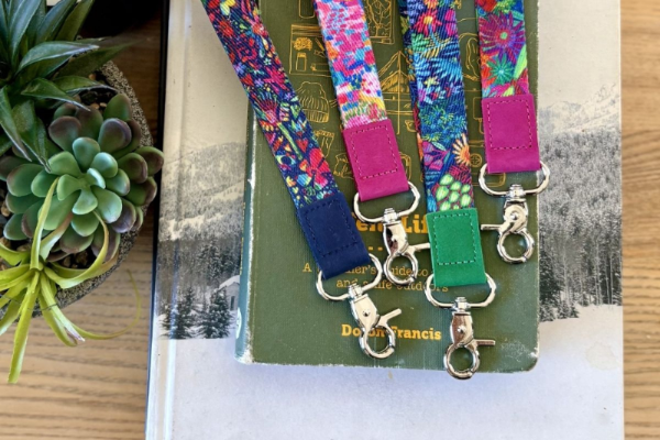 Colorful lanyards with keychains on a book with plants in the background