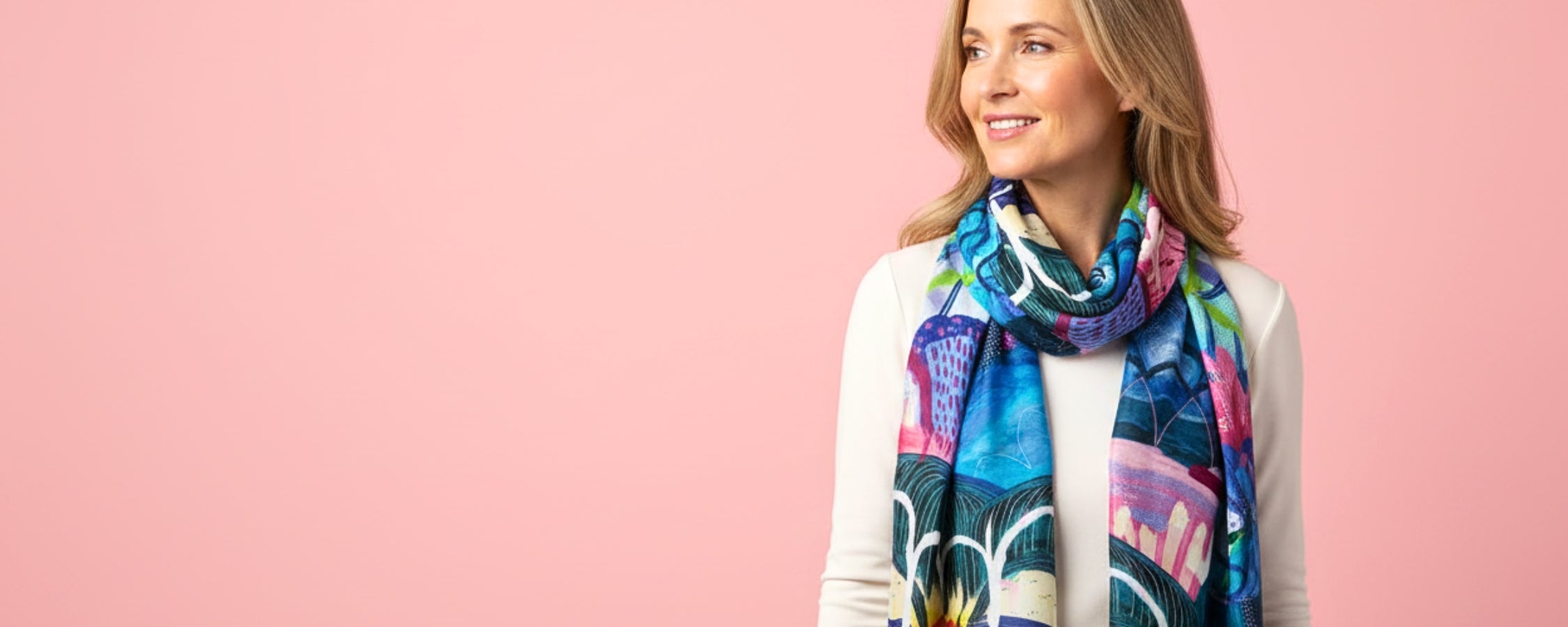 Woman wearing a colorful scarf against a pink background