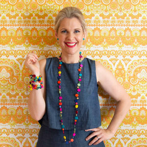 Smiling blonde women wearing colourful jewellery.