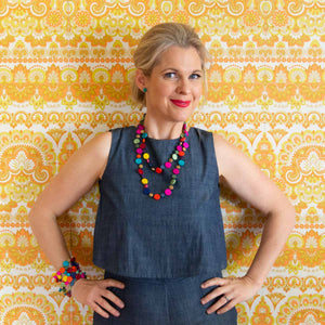 Smiling blonde women wearing colourful jewellery.