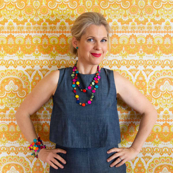 Smiling blonde women wearing colourful jewellery.