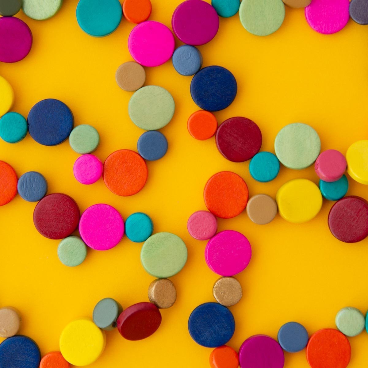 Multi coloured beaded jewellery on a yellow background.