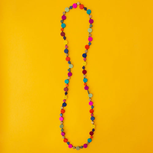 Long Rainbow coloured beaded necklace on yellow background.
