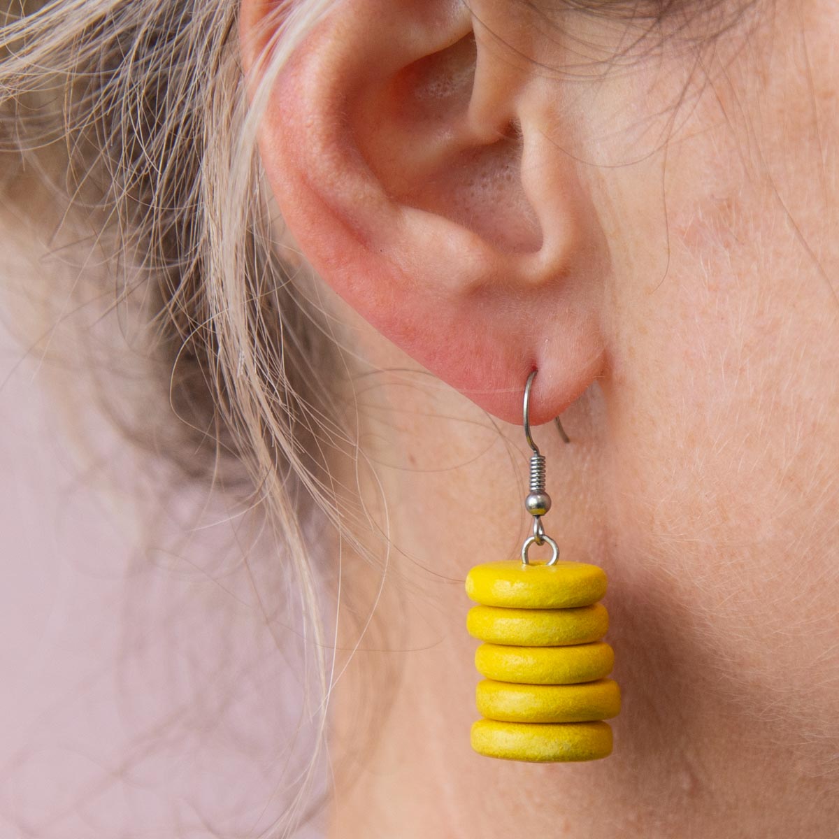 Blonde women wearing bright yellow drop earrings.