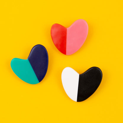 Heart shaped brooches on yellow background.