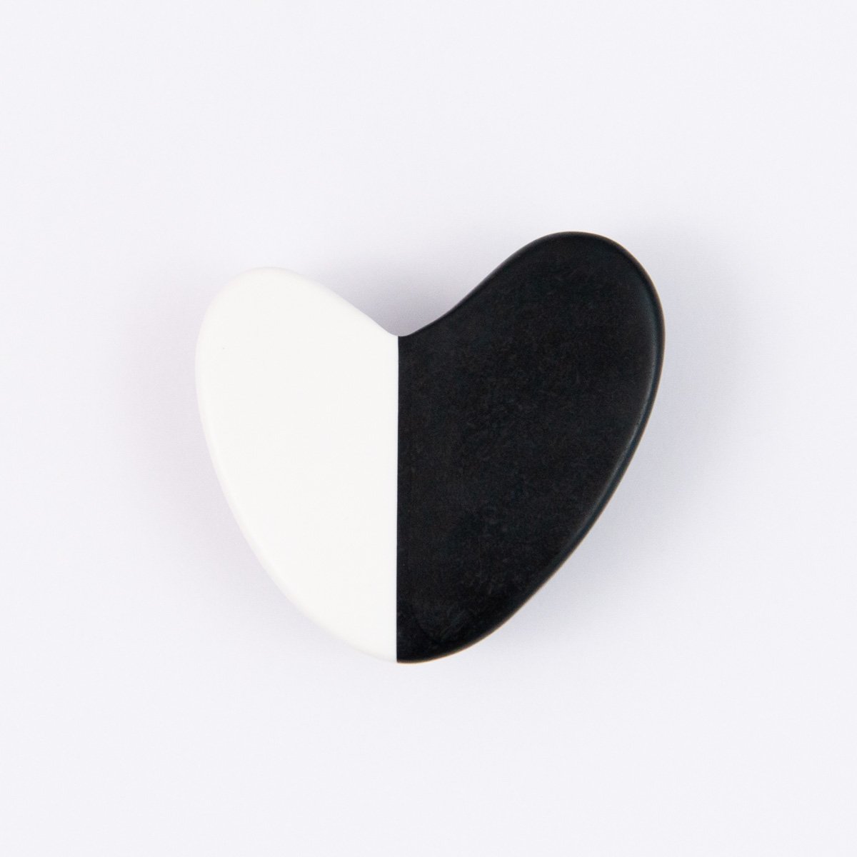 Black and white heart shaped brooch on white background.